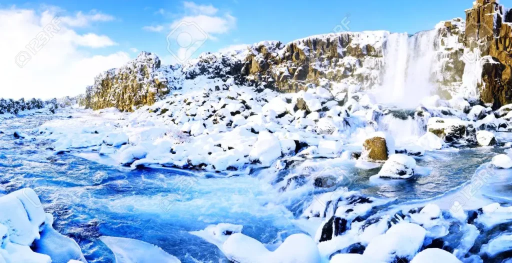 Snowy and partly frozen Öxarárfoss waterfall in Þingvellir, Iceland