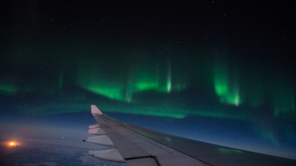 Northern lights seen from an airplane window over Iceland